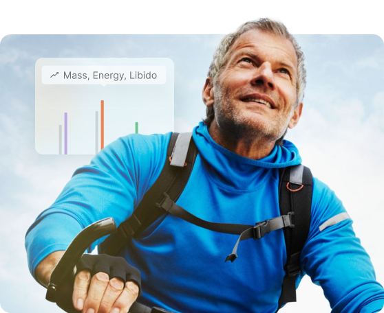 A smiling older man in a blue athletic jacket rides a bicycle outdoors